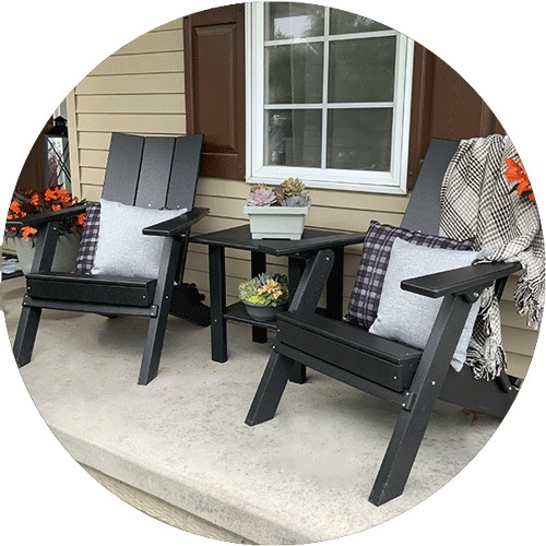 Set of two black chairs and a black side table sitting on a front patio.